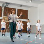 How does a PE teacher raise the coaching and officiating with students?